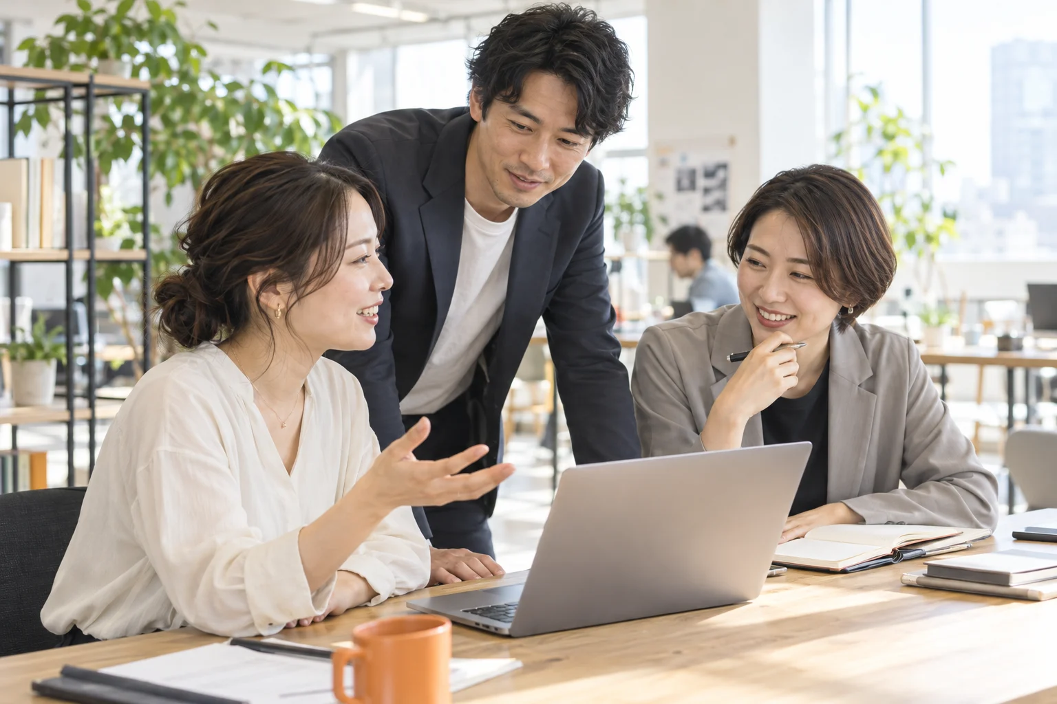 明るいオフィスで仕事について話し合う人々のイメージ